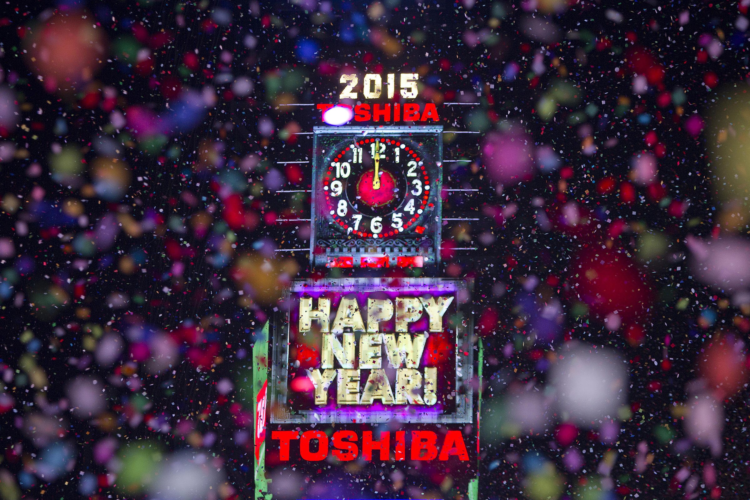 Confetti flies around the ball and countdown clock in Times Square on New Year's Eve in New York January 1, 2015. REUTERS/Carlo Allegri (UNITED STATES - Tags: SOCIETY ANNIVERSARY) - RTR4JSGR